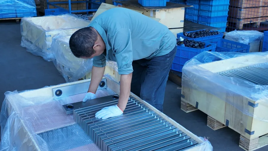 Log 15: 350 Aluminum Forged Support Brackets Packed for Germany(Image2) Worker positioning a long aluminum forged support bracket during packing