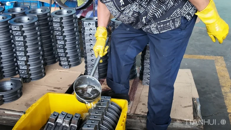 Log 16: 1,000 6-Inch Stepped Butterfly Valve Bodies for Brazil(Image6) Operator pouring liquid over stepped butterfly valve bodies in a yellow tray