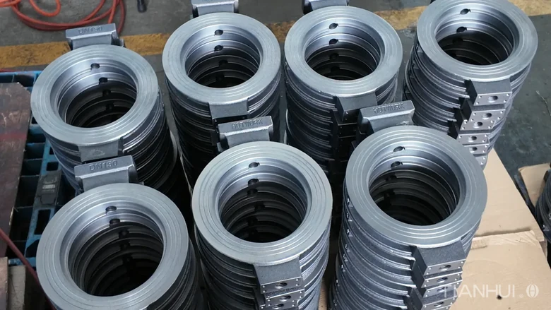 Log 16: 1,000 6-Inch Stepped Butterfly Valve Bodies for Brazil(Image2) Six-inch stepped butterfly valve bodies stacked with circular openings visible